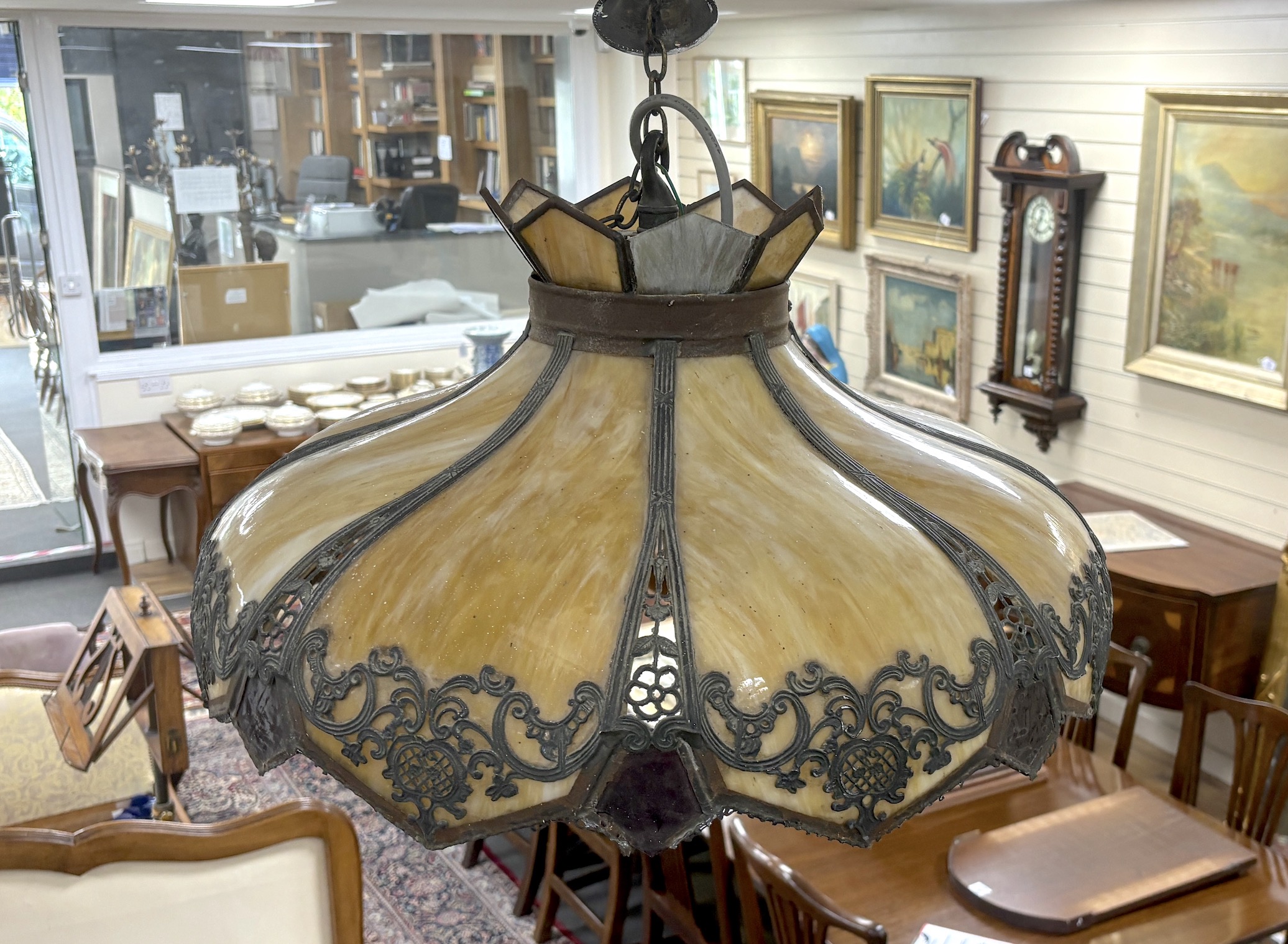 An early 20th century stained glass hanging lamp shade with applied metalwork decoration, shade 56cm diameter
